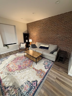 A living room with a sofa, coffee table, and patterned rug. - Perfect 3-bedroom apartment in the heart of Port Clinton (Port Clinton)