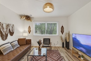 A living room with a sofa, coffee table, and TV. - Cozy Stylish Apt in Omaha`s Medical District! (Omaha)