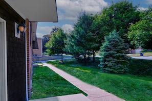 A residential property with a well-maintained lawn, a pathway leading to the entrance, and a brick exterior wall. - Prime Location! HGTV Design! (Omaha)
