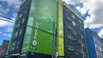 A multi-story hotel with a green facade and a sign indicating it is Planet 3.