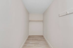 A narrow hallway with a wooden floor and white walls. - Prime Location! HGTV Design! (Omaha)