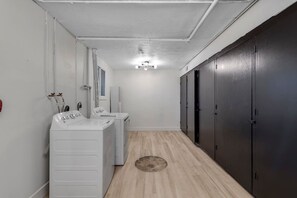 A laundry room with a washing machine, dryer, and a row of black lockers. - Prime Location! HGTV Design! (Omaha)