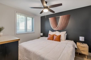 A bedroom with a bed, a desk, a ceiling fan, a window with blinds, and a wall-mounted hammock. - Prime Location! HGTV Design! (Omaha)