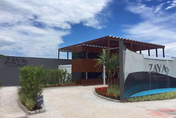 A modern building with a covered outdoor area, a pool, and a sign that reads 'ZAY'S.' - Zaya Motel Premium (Florianópolis)