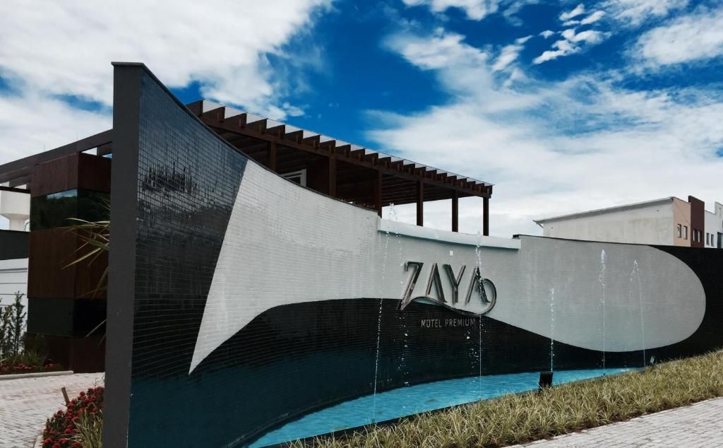 Un edificio moderno con una estructura prominente en forma de ola y el nombre 'ZAYAS'.