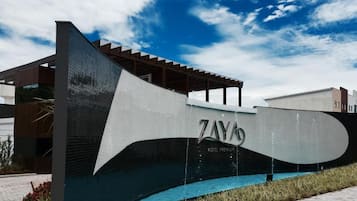Un edificio moderno con una estructura prominente en forma de ola y el nombre 'ZAYAS'.