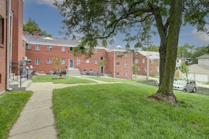 A residential building with a brick exterior, a grassy lawn, and a tree. - Prime Location Midtown Omaha! (Omaha)