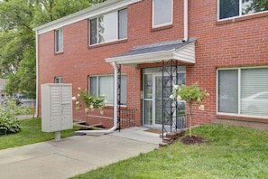 A brick building with a covered entrance, a mailbox, and two potted plants. - Prime Location Midtown Omaha! (Omaha)