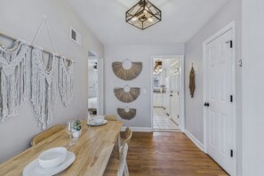 A dining area with a wooden table, white chairs, and a white bowl. - Prime Location Midtown Omaha (Omaha)