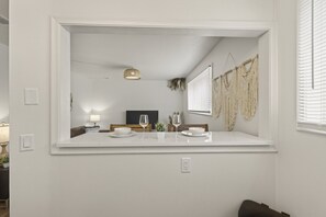 A bathroom with a large mirror, a ceiling light, a towel rack, and a window with blinds. - Cozy Stylish Apt in Omaha`s Medical District! (Omaha)