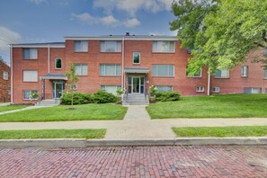 A multi-story brick building with a central entrance, a small porch, and a well-maintained lawn. - Prime Location Midtown Omaha (Omaha)