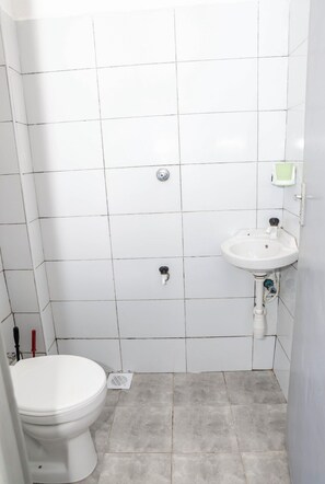 A small bathroom with a toilet, a sink, and a shower. - Modern Studio In Mtwapa, Kenya (Mtwapa)