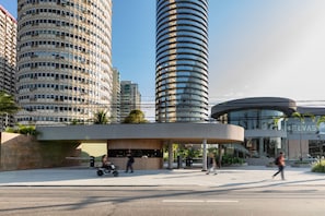 A modern building with a curved glass facade, surrounded by high-rise buildings. - Niemeyer 360 (Rio de Janeiro)