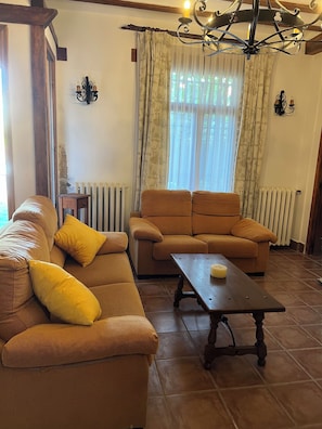 A living room with a sofa, a coffee table, and a radiator.