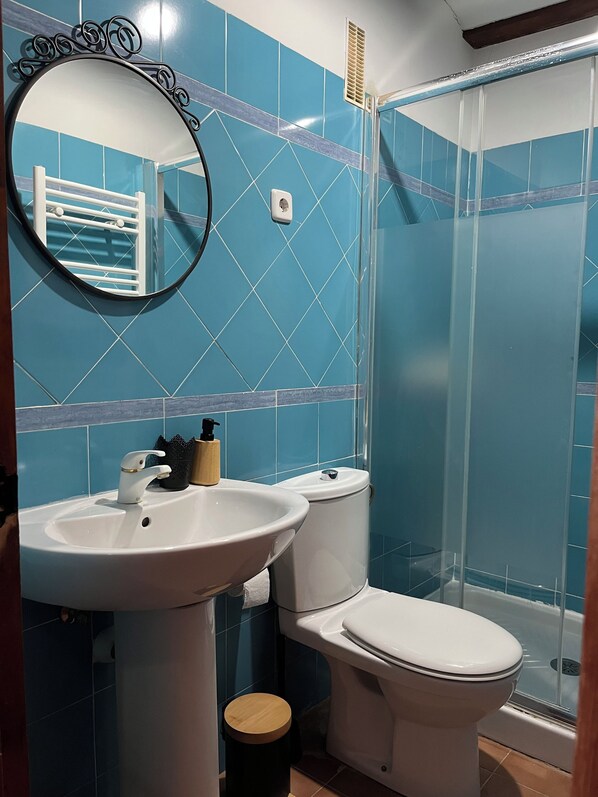 A bathroom with a sink, toilet, and shower.