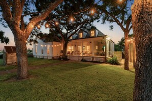 A two-story house with a porch, surrounded by trees and a well-maintained lawn. - 1868 R. H. Wood House | Historic Rockport Retreat (Rockport)