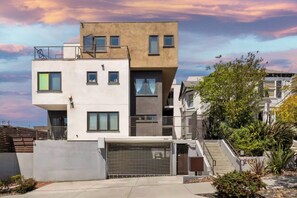 A modern multi-story residential building with a flat roof, large windows, and a garage. - Bay Views & Walk to Little Italy - Prime Location (San Diego)