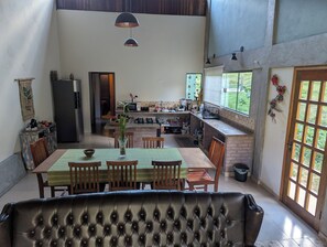 Eine geräumige Küche mit Essbereich, ausgestattet mit einem großen Tisch, Stühlen und einer Couch.