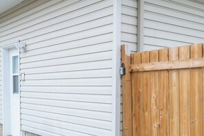 A house with white siding and a wooden gate. - 2BR Suite - 4 Min Walk to WEM - Free Parking (Edmonton)