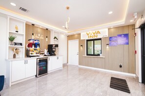 A reception area with a VIVA INN sign, a coffee machine, a refrigerator, and a vending machine. - Viva Inn (Houston)