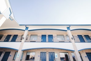 A multi-story building with a flat roof and a series of balconies. - Viva Inn (Houston)