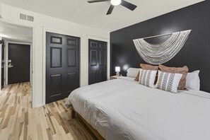 A bedroom with a bed, a ceiling fan, and a wall-mounted light fixture. - Cozy Stylish Apt in Omaha`s Medical District! (Omaha)