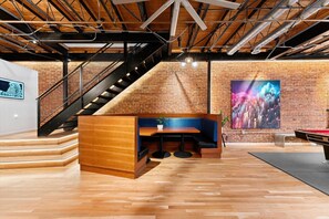 Un interior modern amb una banca de fusta, una escala i un gran quadre abstracte a la paret.