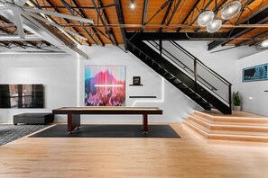 A modern interior with a pool table, a staircase, and a large abstract painting. - HR of Denver (Denver)