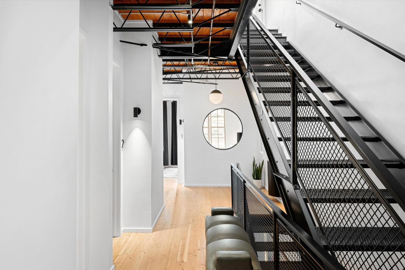 Ein modernes Interieur mit einer Treppe, einem runden Spiegel und einer Tür mit einer Nummer.