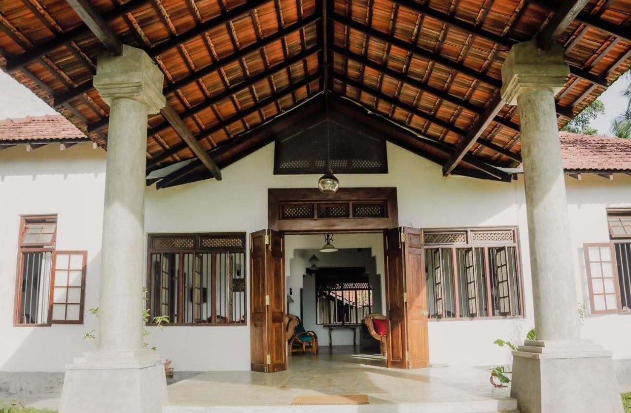 A traditional building with a tiled roof, wooden columns, and a central doorway.