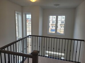 A balcony with a black railing and a view of a building under construction. - Spacious 4-bedroom 4 Bathroom House Near Wasaga Beach (Wasaga Beach)