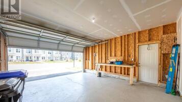 A garage with a workbench, tools, and a ladder.