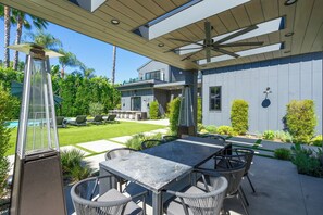 Eine moderne Außenpatio mit Esstisch, Stühlen und einem Poolbereich.