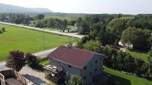 A two-story building with a red roof, a fenced yard, and a soccer field. - Blue Mountains Chalet | Sleeps 18 | Hot Tub & BBQ I 1 Minute Drive to Village (The Blue Mountains)