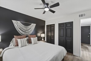 A bedroom with a bed, a ceiling fan, a wall-mounted hammock, and a set of double doors. - Cozy Stylish Apt in Omaha`s Medical District! (Omaha)