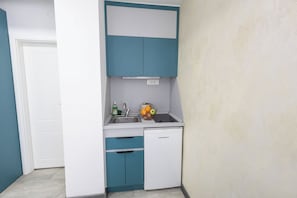 A compact kitchen with a sink, a dish rack, and a small refrigerator. - Astera Apart Hotel -Cozy studio with AC in gorgeous Skopje perfect for your stay (Skopje)