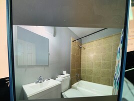 Un baño con lavamanos, inodoro y bañera blancos.
