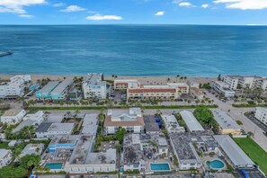 Un hotel costero con varias edificaciones, una playa y vista al océano.