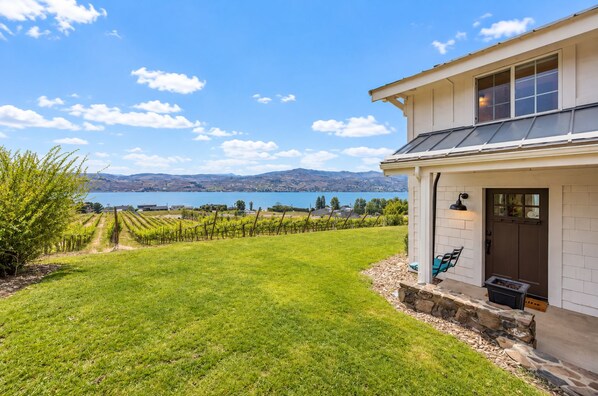 Una casa con vistas a un viñedo y un lago.