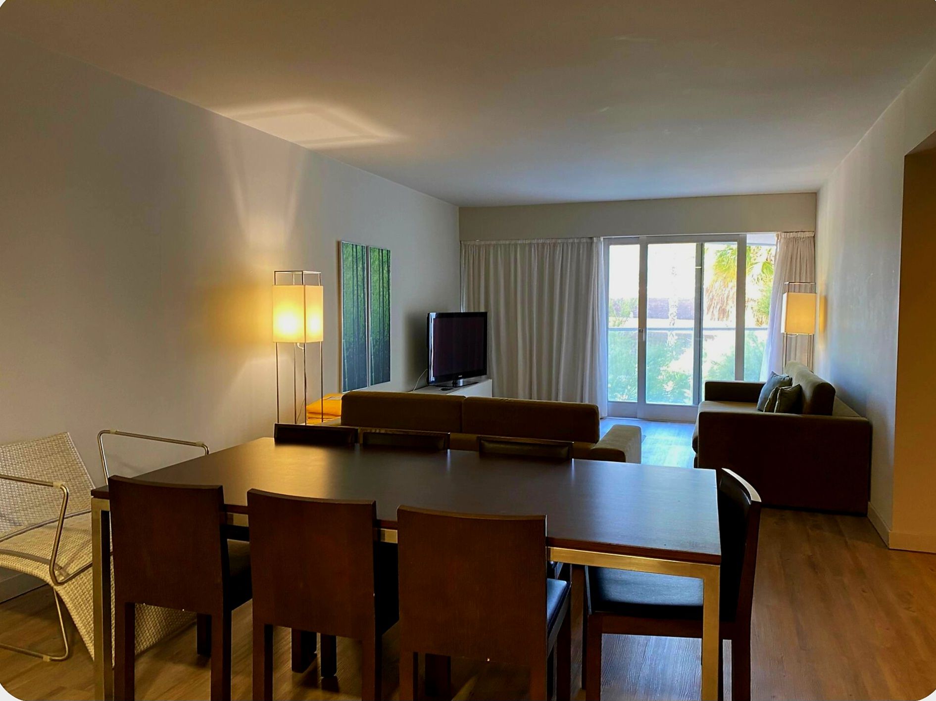Une chambre d’hôtel équipée d’une table à manger, de chaises, d’un téléviseur et d’un canapé.