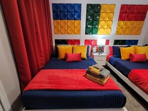 A hotel room with two beds, red curtains, and a colorful wall panel. - Fantasy World Resort, The Lego House - Free Waterpark and free Disney Shuttle (Kissimmee)