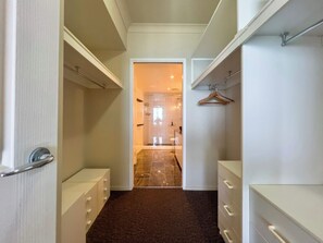 A hallway with a door leading to a bathroom, a coat rack, and a mirror. - Azure 41 Level 41 Ocean Views, Surfers (Surfers Paradise)