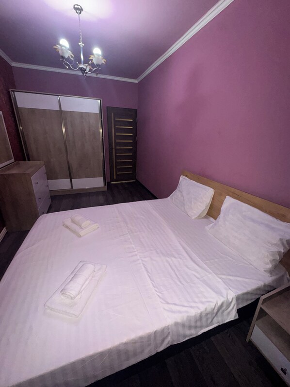 Un dormitorio con una cama, un armario y una puerta.