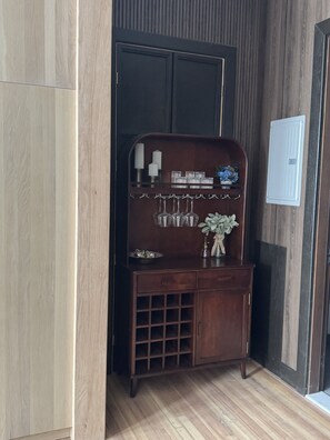 Ein Holzschrank mit Weinkühler, eine kleine Ablage mit Dekorationen und eine Schubladenkommode.