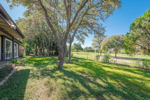Propiedad residencial con césped cuidado, árboles maduros y vista despejada del vecindario.