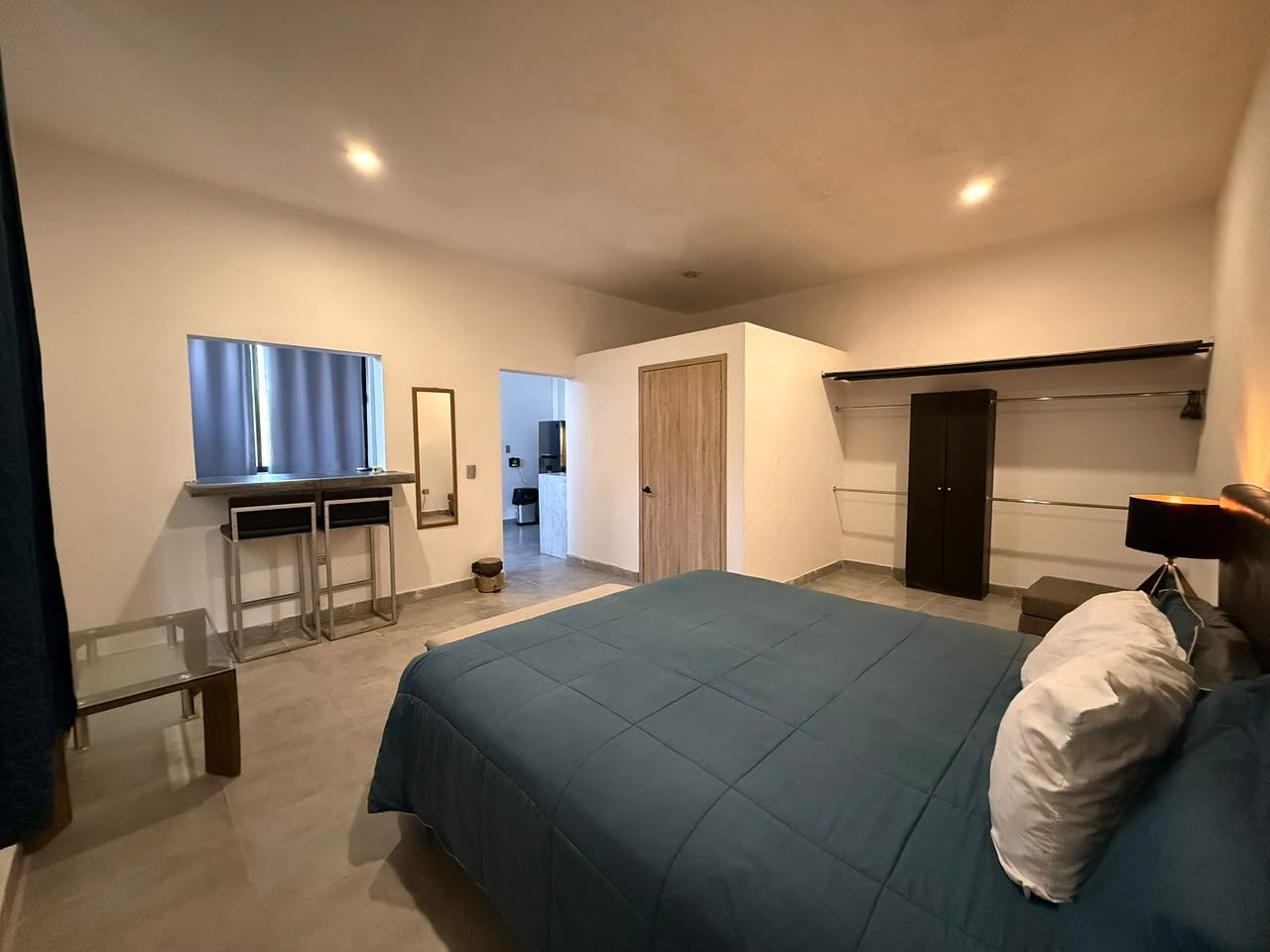Une chambre à coucher moderne avec un grand lit, un bureau et une armoire.