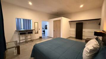 Une chambre à coucher moderne avec un grand lit, un bureau et une armoire.