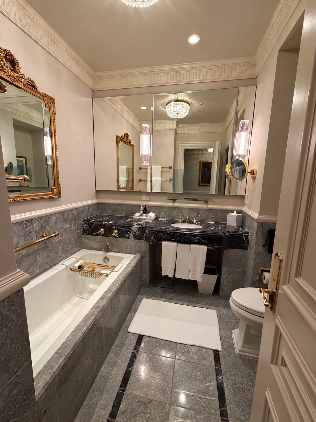 A luxurious bathroom with a large bathtub, a separate shower area, a double sink vanity, and a toilet.