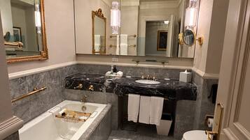 A luxurious bathroom with a large bathtub, a separate shower area, a double sink vanity, and a toilet.