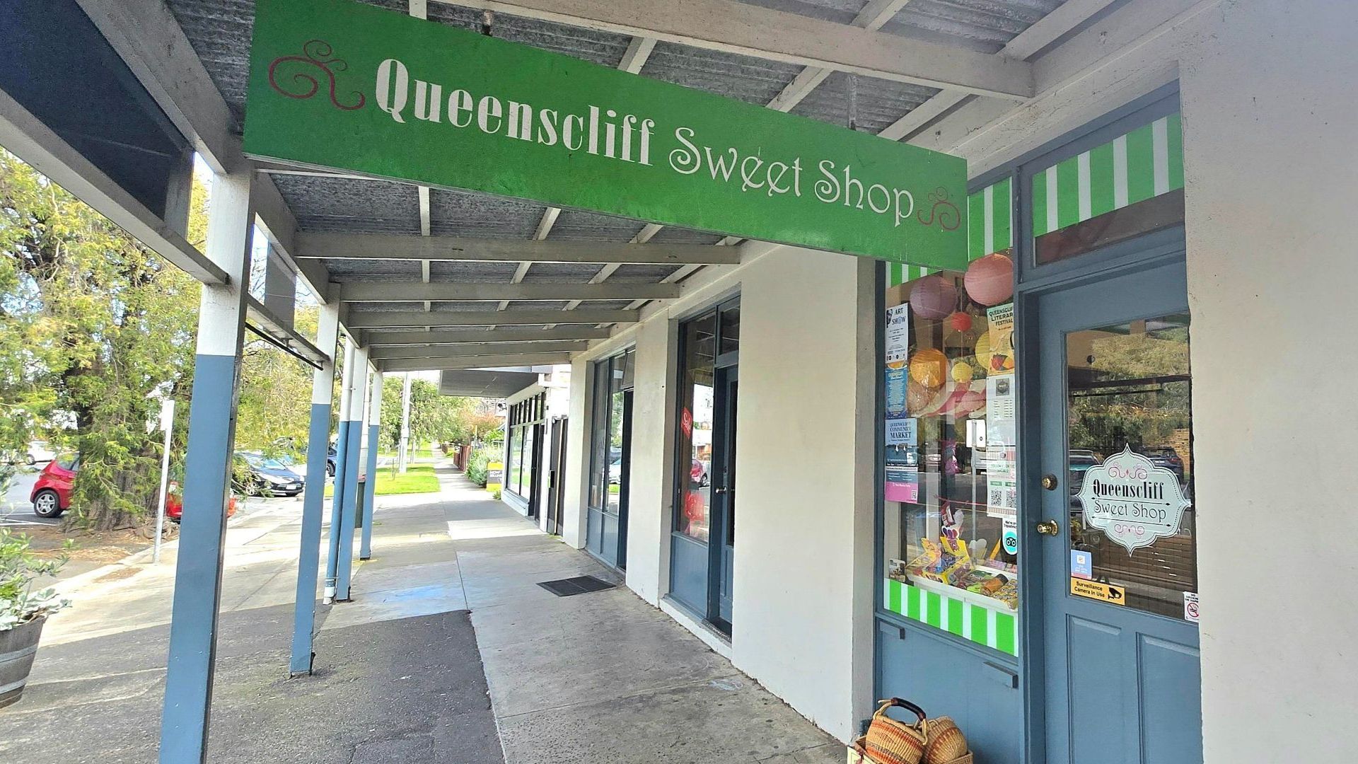 A storefront with a green sign reading 'Queenscliff Sweet Shop.'